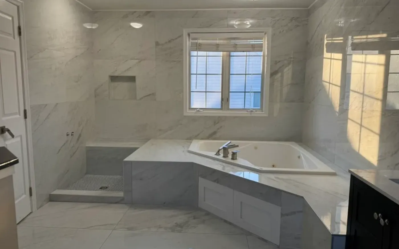 White veined-tile bathroom with corner tub and shower
